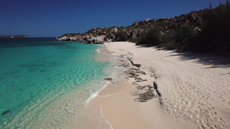 spiaggia caraibica tropicale con oceano blu turchese, spiaggia nascosta appartata in paradiso con cielo blu, onde d'acqua turchesi dell'oceano calmo