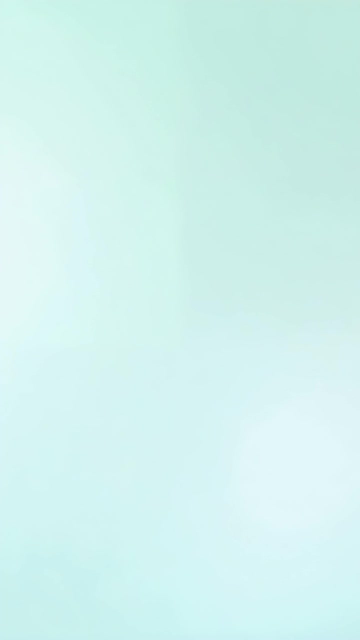 Vertical video: Shifting mint gradient moving across wall from soft light change, with left glow