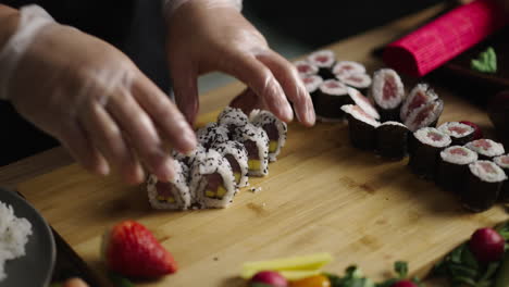 close-up of hands making sushi rolls on a cutting board