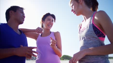 multi ethnic friends planning fitness activity by ocean