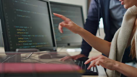 programadores de ti discutiendo el proyecto en la oficina de primer plano. manos escribiendo código de computadora