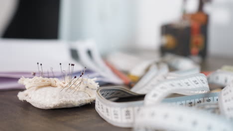 round view of measuring table and needles, essential for garment production, focusing on precise dimensions, showcasing creativity in sewing craft, emphasizing accurate cutting and pinning