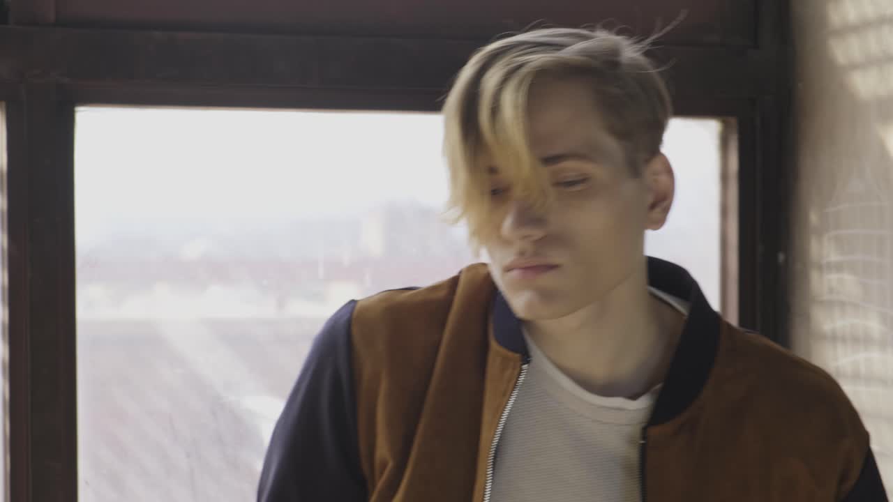 ⁇ 은 방의 창문 근처에 앉아 있는 젊은 남자