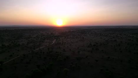 Puesta-De-Sol-En-El-Terreno-Del-Serengeti-Africano-Visto-Desde-Arriba,-Toma-Aérea-De-La-Muñeca-Izquierda