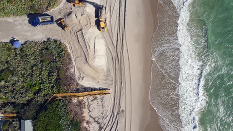 straight overhead aerial shot of excavation work happening on the beach