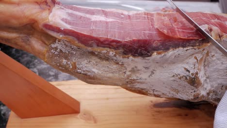 Side-view-of-spanish-jamon-leg,-ham-leg,-on-holder-for-cutting