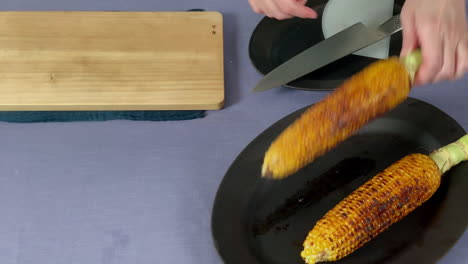 a-Japanese-female-chef-puts-corn-on-the-cutting-board-at-her-home-kitchen,-Tokyo,-Japan