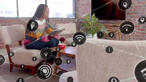 animación de la red de conexiones con iconos wifi sobre mujer afroamericana usando tableta