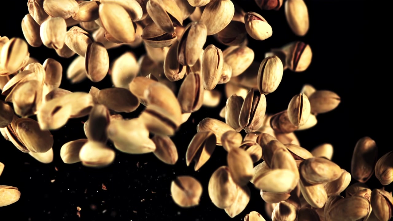Pistacchi che cadono al rallentatore su sfondo nero