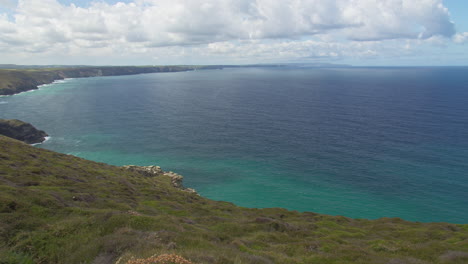 Beautiful-blue-waters-of-Cornwall,-England-on-a-sunny-day---pan-right-slow