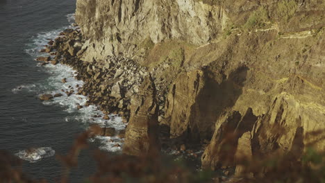 handheld shot from hill of high cliffs by ocean coast at the azores