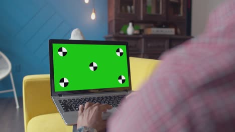 la mujer usa un portátil con una pantalla verde en el escritorio de la oficina. la mujer conduce un touchpad en la computadora portátil en la oficina, chromakey