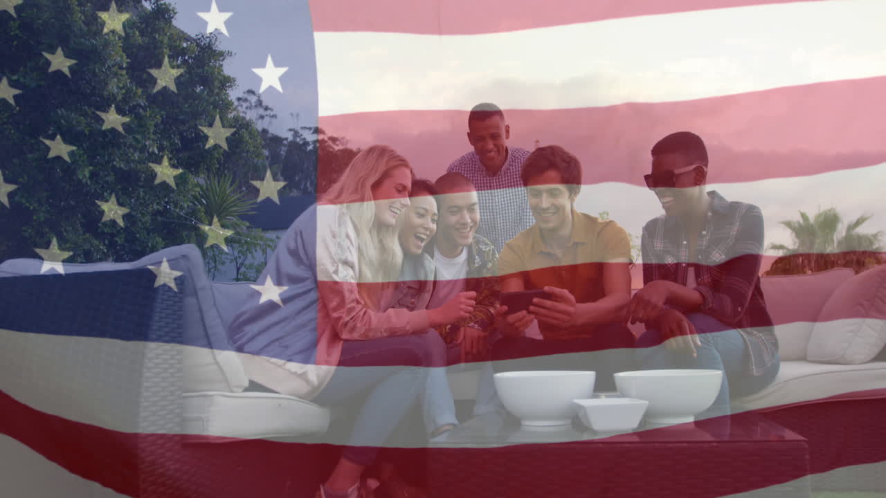 Animation of flag of america waving over happy diverse friends watching video on cellphone