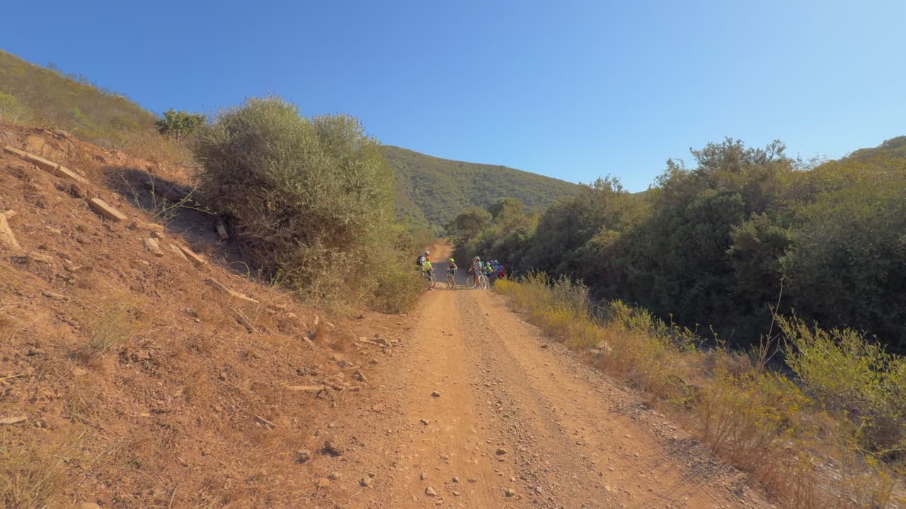 Group of senior citizens standing in shade from sun on cycling trail Algarve Portugal