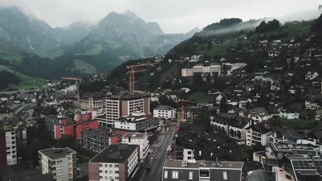 drone aerial of the swiss town of endelberg going up and panning down on cloudy day in between mountains