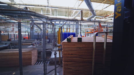 interior of factory for wooden production. wooden boards for floor parquet inside the huge industrial plant. piles of plywood in the manufacturing.