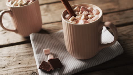 video of mugs of chocolate, marshmallows, christmas decorations and copy space on wooden background