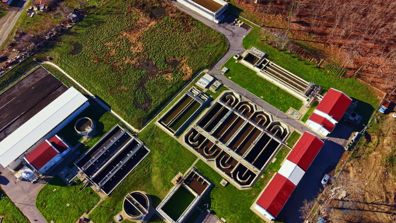 Aerial view of a water treatment facility showing pools, buildings, and surrounding landscape in daytime