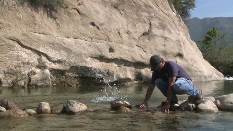 man removing rocks from a fish barrier on the ventura river preserve in ojai california