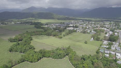 Vista-Aérea-De-Campos-Verdes-Y-Casas-En-La-Ciudad-Rural-De-Mossman-En-El-Condado-De-Douglas,-Queensland,-Australia---Disparo-De-Drones