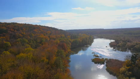 nature landscape in autumn. panoramic view of idyllic forest with bright trees in fall season and river. orange, green, yellow, red leaves treetops of woods. aerial view