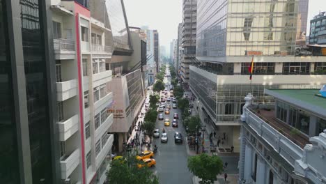 Aerial-view-flying-over-and-towards-Avenue-9-de-Octubre-in-Guayaquil,-the-main-Avenue-in-the-city