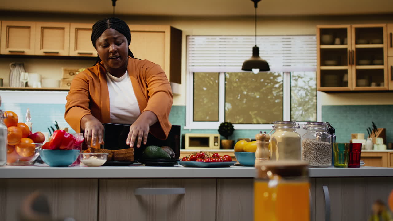 Influenceuse culinaire afro-américaine préparant de l'avocat et des toasts avec un grille-pain