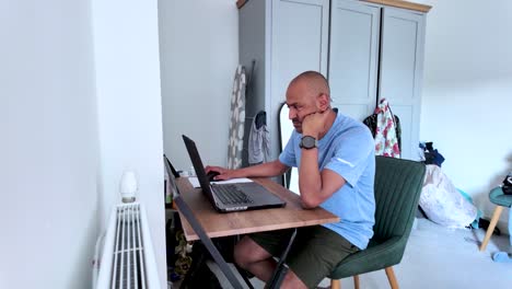 south asian man working from home in his bedroom using laptop computer