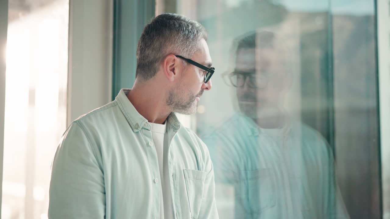 Portrait of a smiling man with glasses by a window
