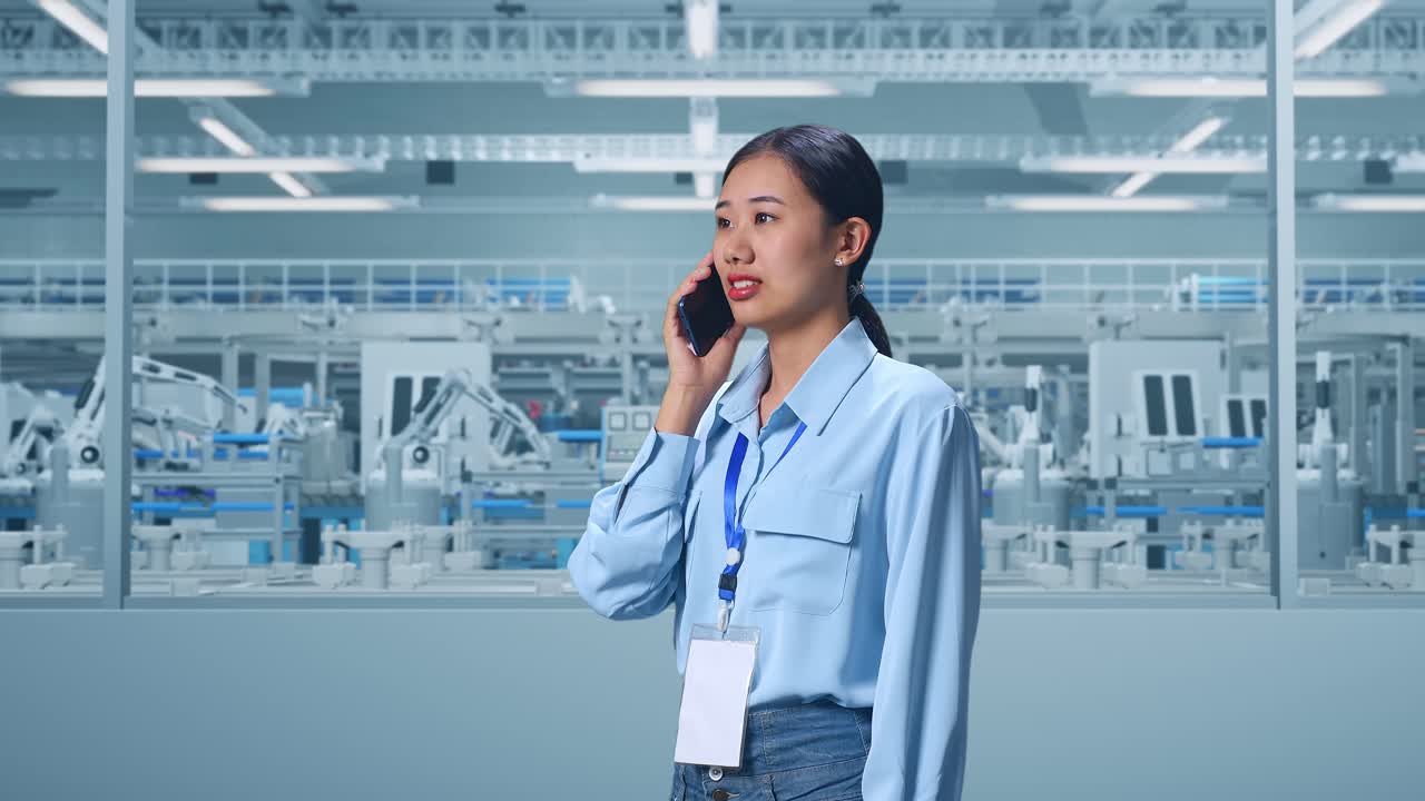 Side View Asian Female Professional Worker Standing at Factory Digitalization for Innovative Project, She Pick The Phone Up And Started To Specking To It With A Slicely Smile