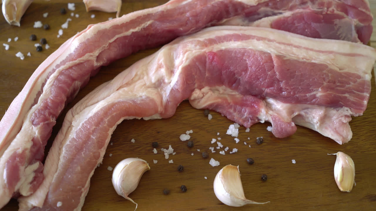 재료가 있는 나무 판자에 있는 신선한 생줄무늬 돼지고기