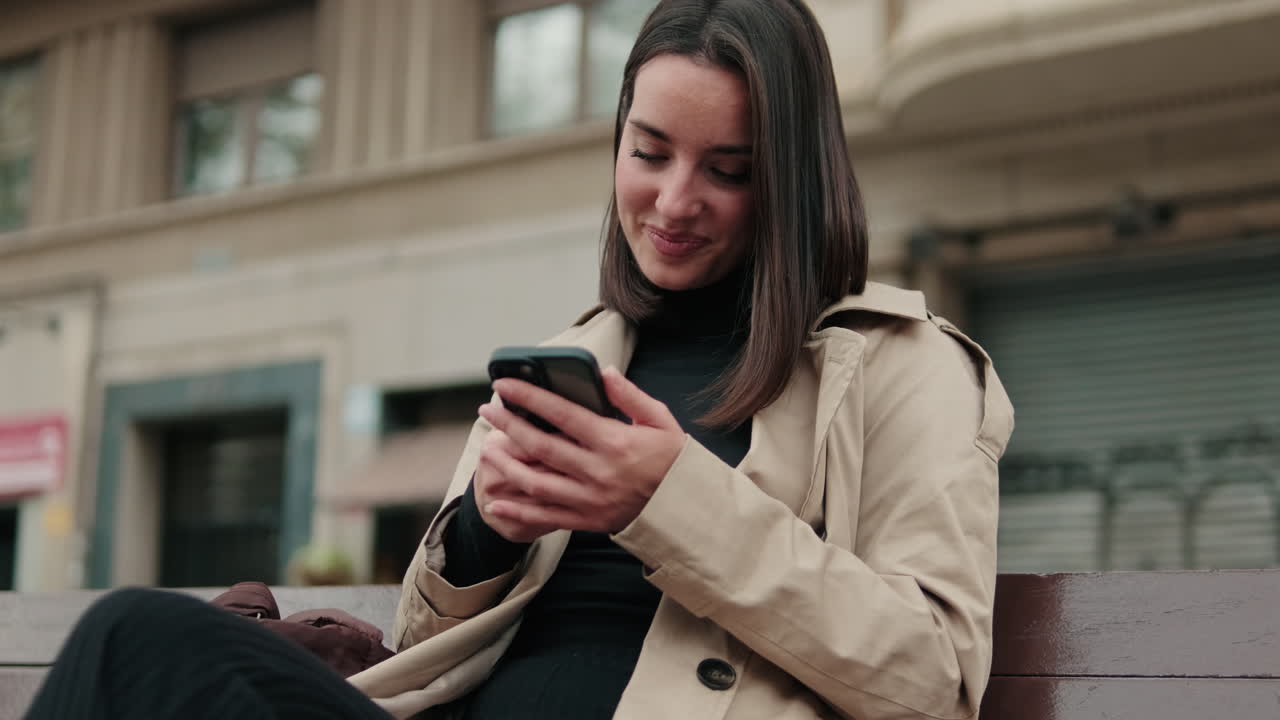 Donna che usa il telefono su una panchina