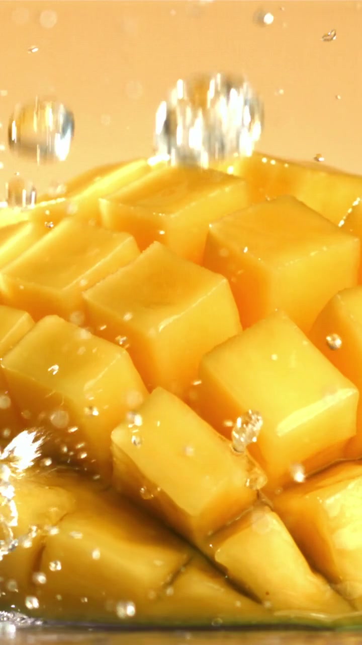 Schizzi d'acqua rinfrescanti su un frutto di mango dorato.
