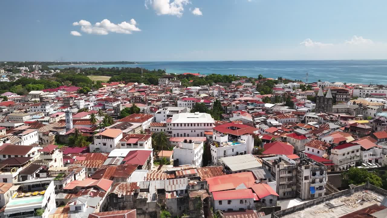 Spettacolare volo cinematografico con drone sopra la Casa delle Meraviglie e gli storici tetti di Stone Town, Zanzibar. L'architettura swahili, l'atmosfera costiera e le texture intramontabili della città creano una scena di viaggio mozzafiato