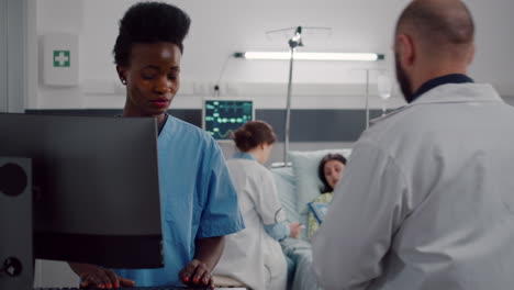 asistente negro escribiendo tratamiento de atención médica en la computadora