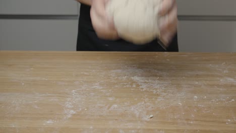 주방 선반 에 손 을  ⁇ 고 피자 반죽 을  ⁇ 는 사람