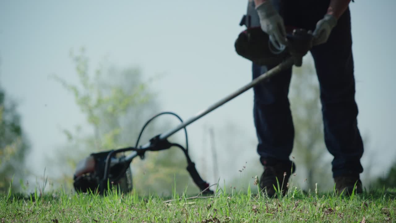 Man Preparing Brush Cutter Outdoors - Medium Shot
