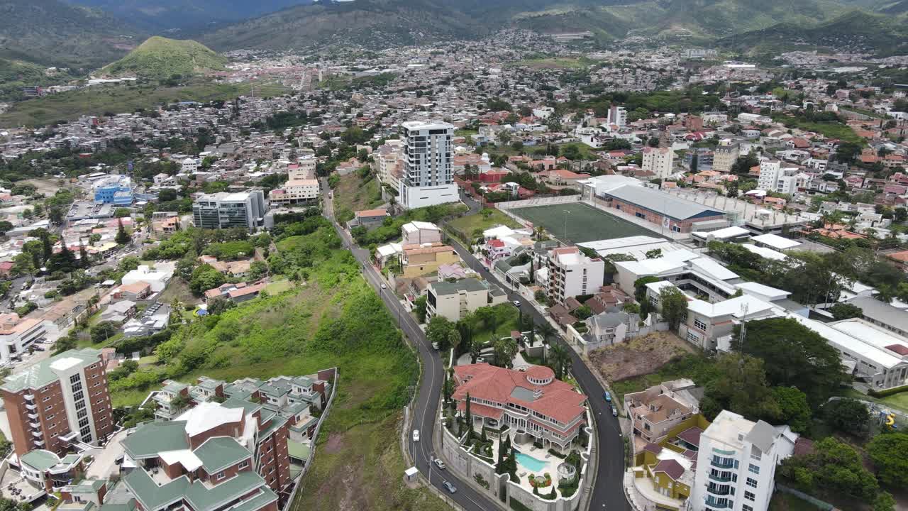 Vista aerea da drone su Tegucigalpa, Honduras, che mostra quartieri residenziali densi, rete stradale curva, edifici di media altezza ed espansione urbana attraverso la valle circondata da colline