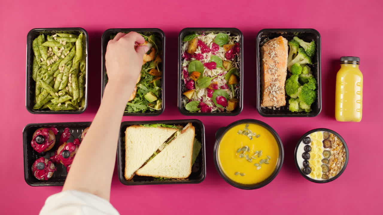 Vista superior de recipientes de comida saludable para preparar comidas sobre un fondo rosa