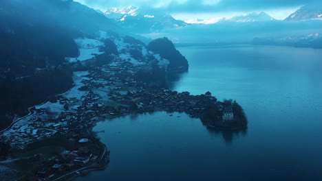 Ausgezeichnete-Luftaufnahme-Des-Schlosses-Auf-Der-Halbinsel-Iseltwald,-Schweiz-Und-Des-Umliegenden-Geländes-In-Der-Abenddämmerung