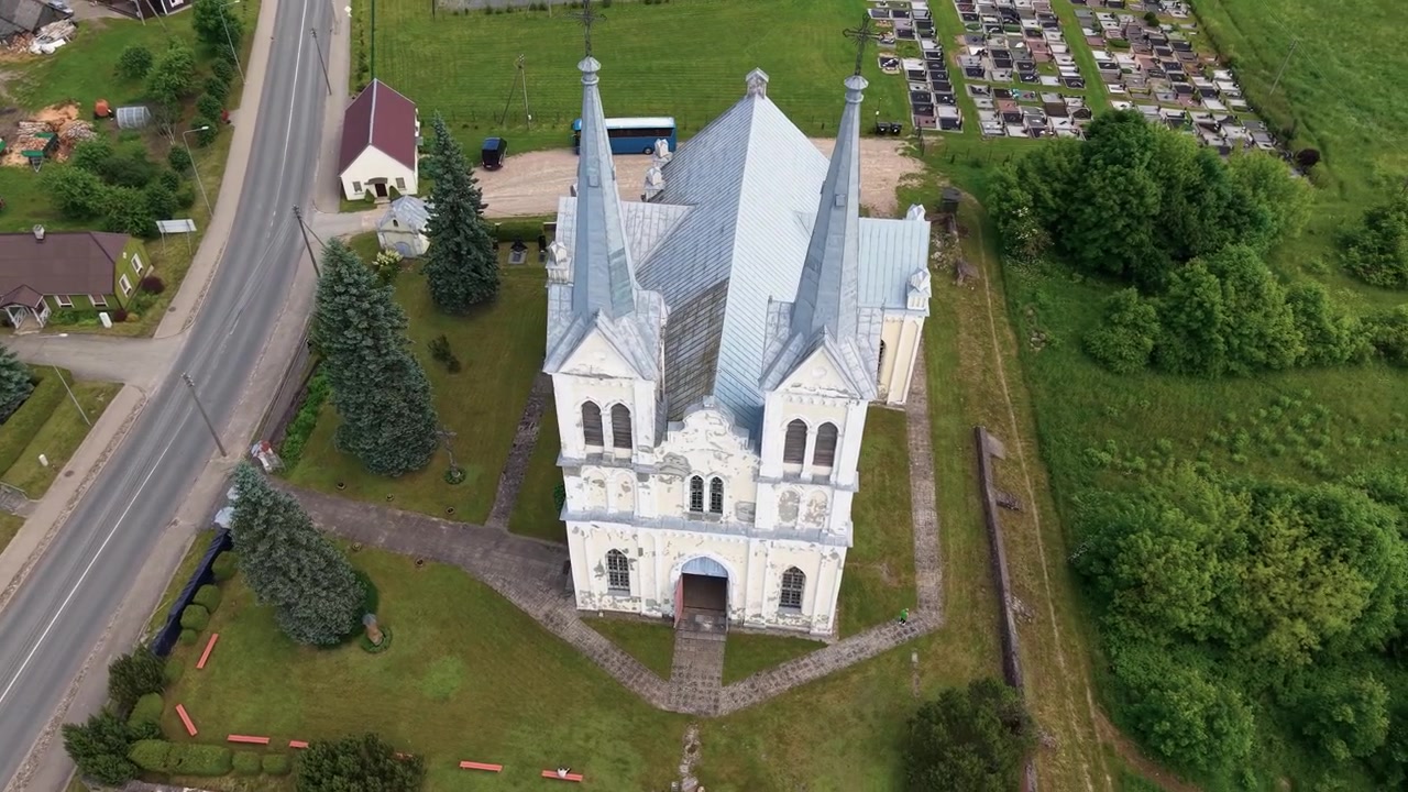 Dronevideo fanger Obeliai St. Anne-kirken i Litauen ovenfra, som avslører arkitekturen, tvillingtårnene, grønne plener, kirkegården og landlige omgivelser i mykt dagslys