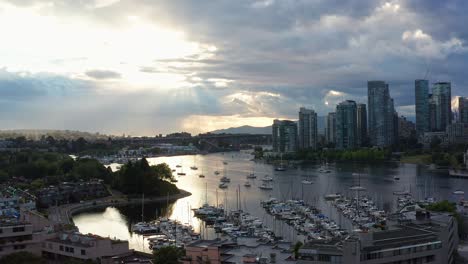 drone aerial shot over the vancouver marina, moving closer to the cityscape on a cloudy day