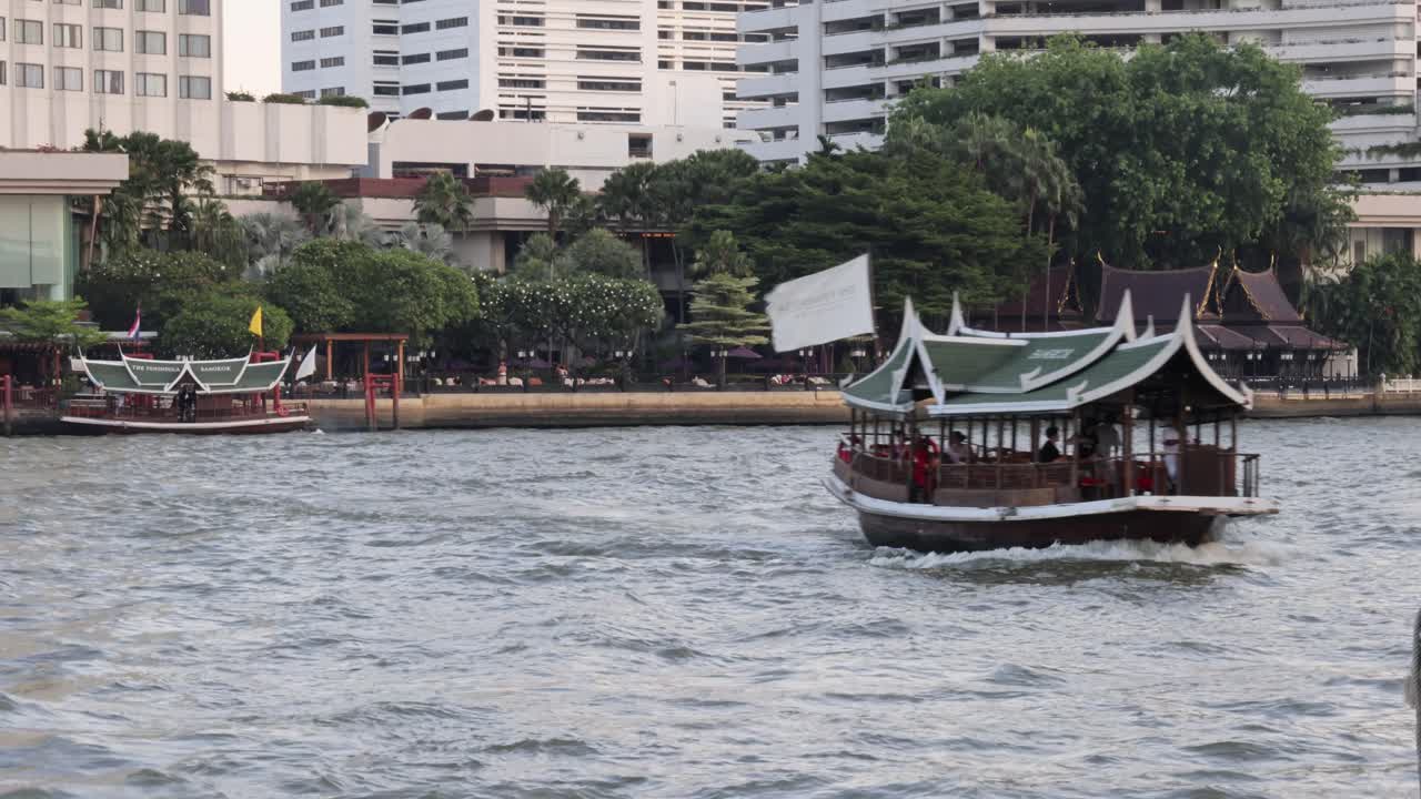 전통적 인 배 가 도시 강 을 따라 항해 한다