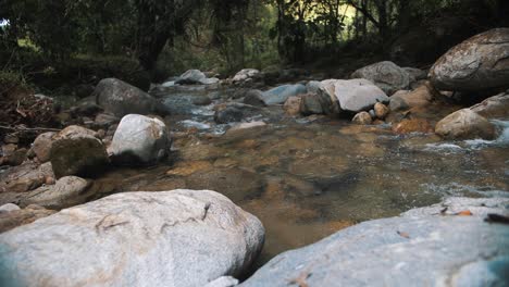 Hermosa-Toma-En-Cámara-Lenta-De-Agua-Que-Fluye-A-Través-De-Rocas-En-Un-Río-En-Medio-De-La-Jungla