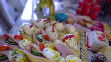 canapes from bagel prepared for an event wedding party with salami cucumber egg peppers bread and sweets on the side creative moving motion cinematic czech slovakian polish gypsy style