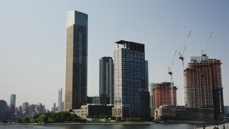 manhattan's skyline sees new residential buildings under construction, clad in orange wraps