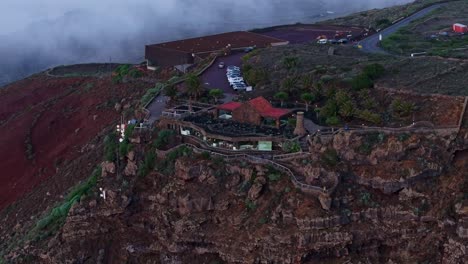 Scenic cliffside restaurant, road overlook in misty El Hierro mountain terrain