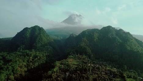 amplia toma cinematográfica del idílico paisaje montañoso y el pico del volcán como telón de fondo - vista aérea