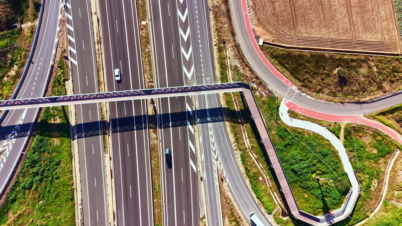 Il traffico scorre su un'autostrada con corsie multiple e percorsi, vista dall'alto di giorno in un contesto urbano e trafficato.