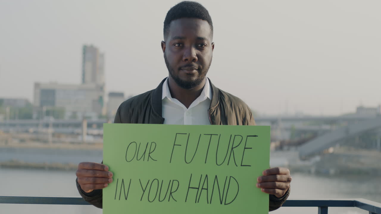 Man Holding a Sign: Our Future in Your Hand